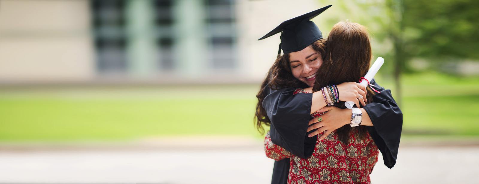 Young Graduate Hugging Her Friend At Graduation Ceremony